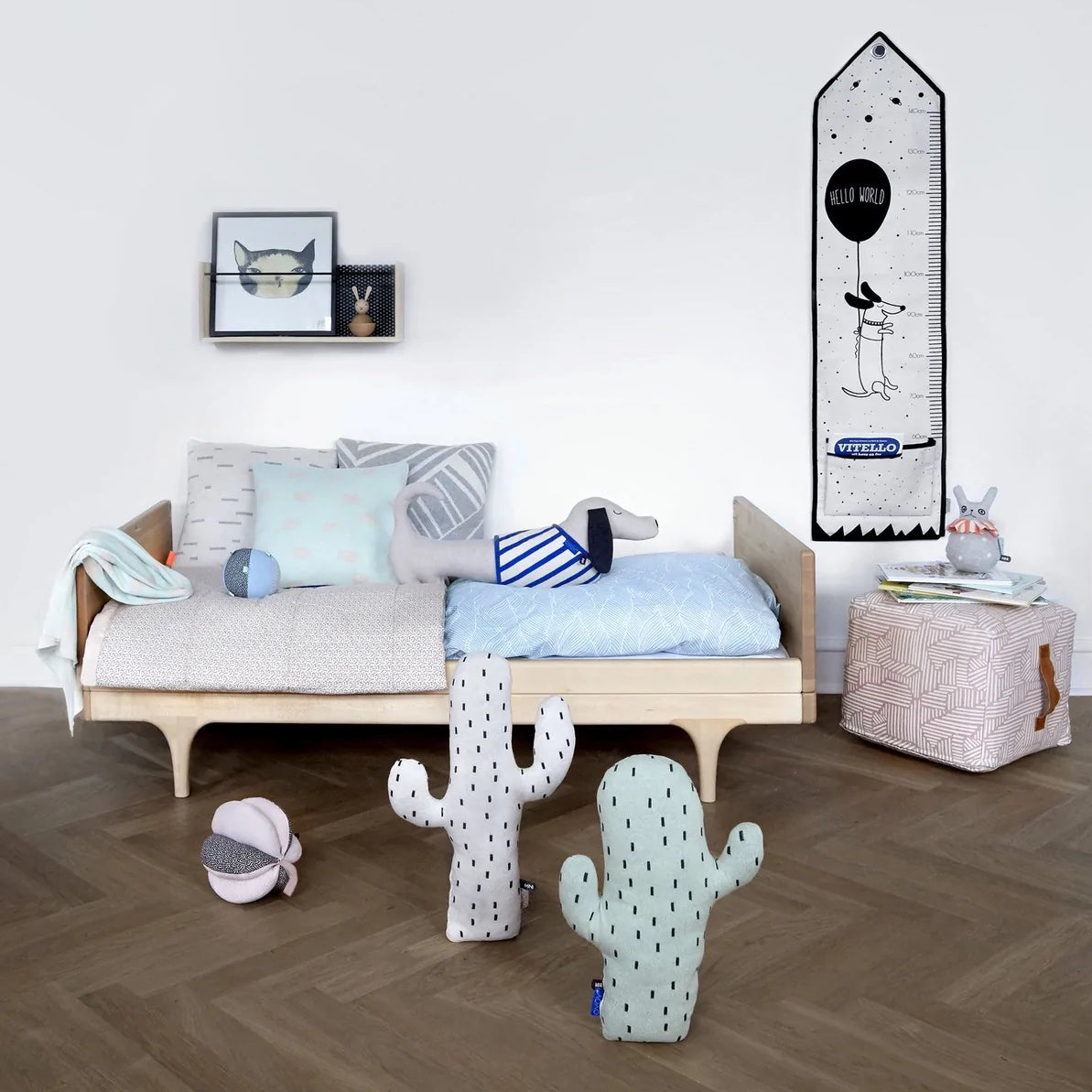 OYOY Slinkii the dog happily snuggling on the day bed of this Scandinavian inspired childrens room setting