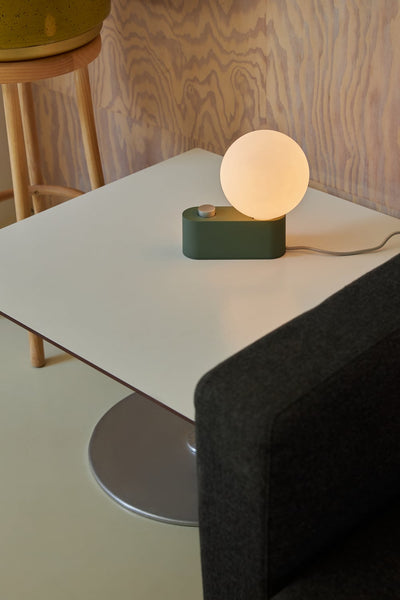 Tala Alumina Lamp as a table light switched on lifestyle image. Free + fast UK delivery from someday designs. #colour_sage