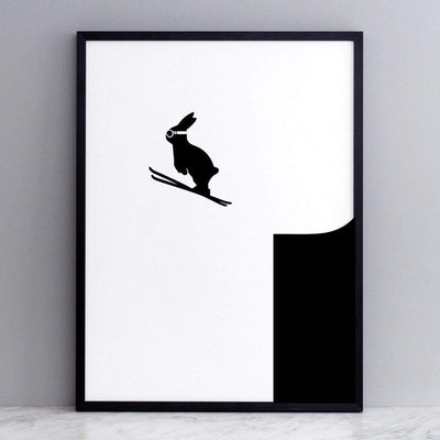 black and white image of HAM rabbit launching off a ski slope.  Fun and playful series of prints.  Ideal for adults and children. Pictured here on marble surface with grey painted wall backdrop.