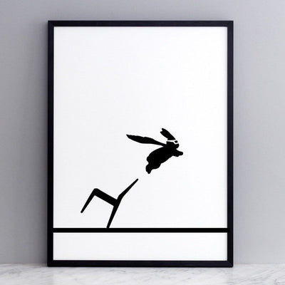 black and white image of HAM rabbit flying to the rescue as a superhero.  Fun and playful series of prints.  Ideal for adults and children. Pictured here on marble surface with grey painted wall backdrop.